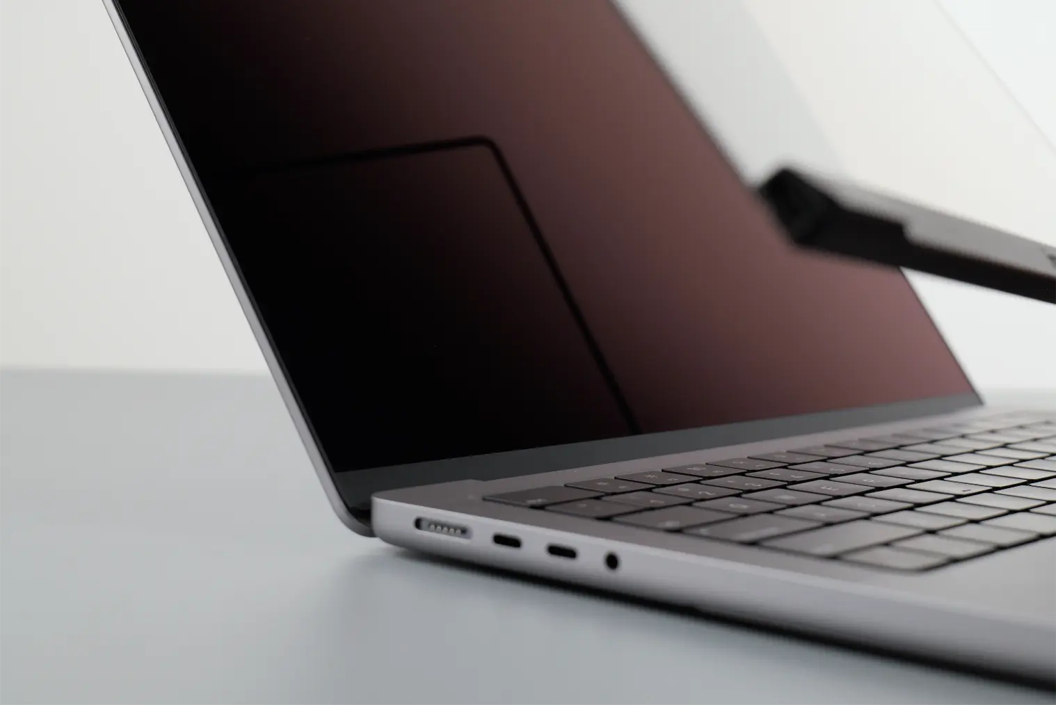 A user lifting up Magic Screen from the MacBook to reveal the untouched display.